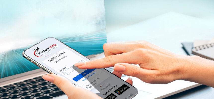 Smartphone screen showing the Flight Pro Connect login form, with a person’s finger about to tap; laptop in the background.